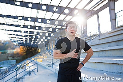 Adult asian athlete sportsman while jogging chest injury, severe heart attack pain, shortness of breath, male runner Stock Photo