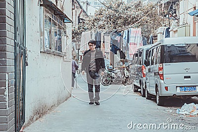 Asian man walking on small side street of Beijing Editorial Stock Photo