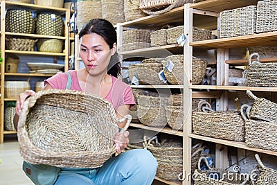 Woman electing wicker basket in housewares store Stock Photo