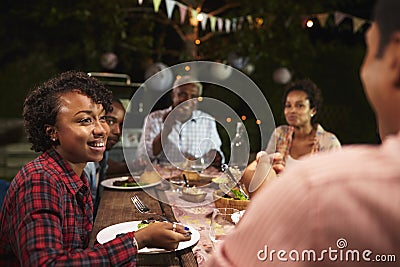 Adult black family eat dinner in garden, over shoulder view Stock Photo