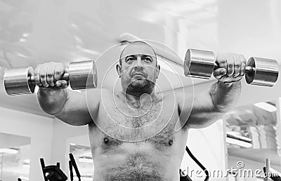 The adult brutal man is engaged in power bodybuilding Stock Photo