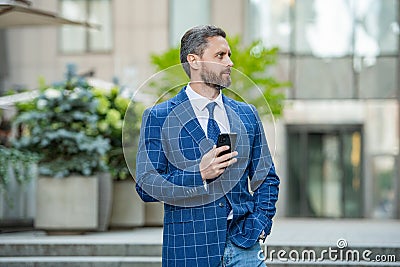 adult businessman messaging on phone outdoor. businessman messaging on phone Stock Photo