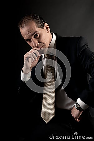 Adult businessman serious thinking dark background Stock Photo