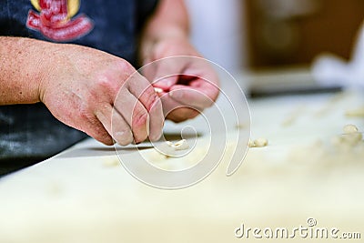 Adult caucasian woman preparing pisarei, italian extruded traditional pasta from Piacenza, Italy Stock Photo