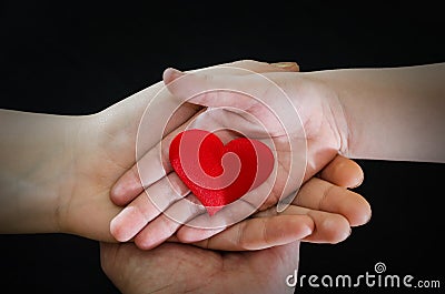 Adult and child hands holding red heart, health care, donate and family insurance concept,world heart day, world health day, CSR c Stock Photo