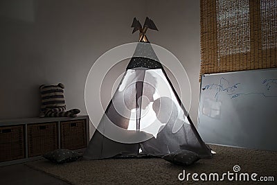 Adult and child sitting in a teepee in the nursery. Stock Photo