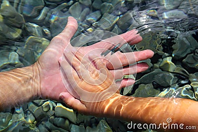 Adult and children hands holding underwater Stock Photo