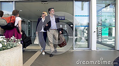 Adult couple leaving airport, people arriving on vacation, family holidays Stock Photo