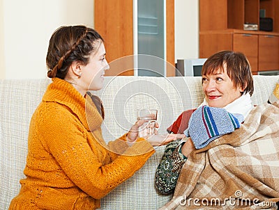 Adult daughter caring for sick mature woman Stock Photo