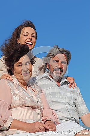 Adult daughter embracing parents and smiling Stock Photo