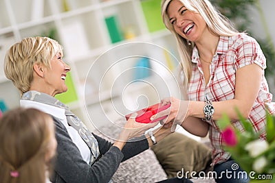 Adult daughter giving to her mother gift for Mother's Day Stock Photo