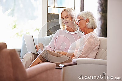 Adult Daughter Helping Senior Mother With Computer At Home Stock Photo