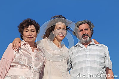 Adult daughter and her parents embracing Stock Photo