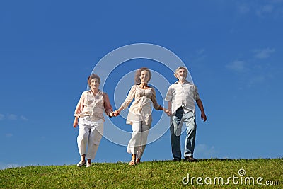 Adult daughter and parents walking on lawn Stock Photo