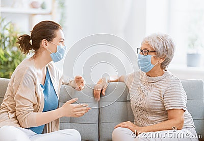 Adult daughter and senior parent wearing facemasks Stock Photo