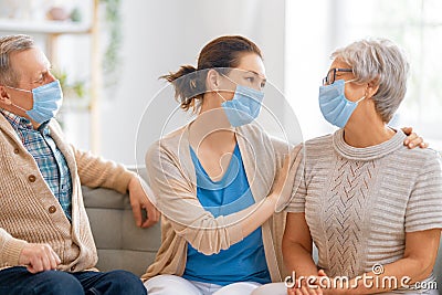 Adult daughter and senior parents wearing facemasks Stock Photo