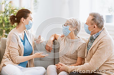 Adult daughter and senior parents wearing facemasks Stock Photo