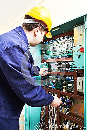 Adult electrician builder engineer worker testing electronics in switch board Stock Photo