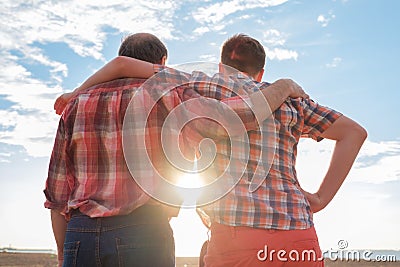 Adult father and son holding hands at sunset Stock Photo
