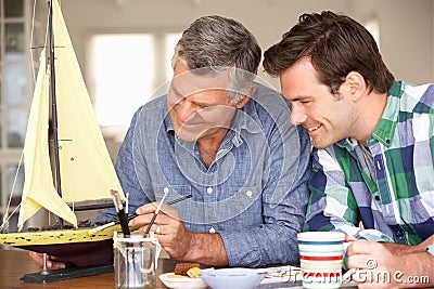 Adult father and son modeling a ship together Stock Photo