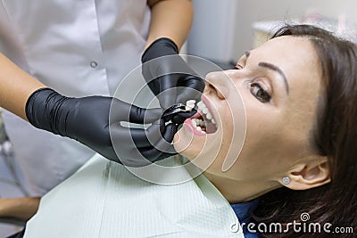 Adult female dentist choosing tooth implant. Medicine, dentistry and healthcare concept. Stock Photo