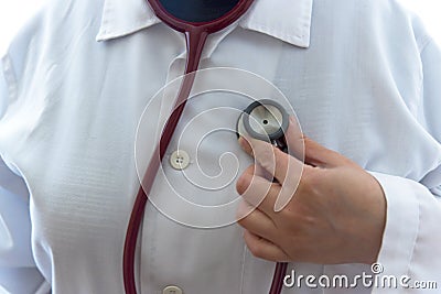 Adult female doctor examine herself with red stethoscope Stock Photo