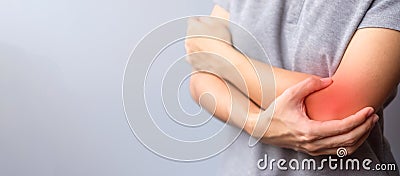 Adult female with her muscle pain on gray background. Woman having elbow ache due to lateral epicondylitis or tennis elbow. Stock Photo