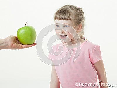 Adult hand giving a green apple for pretty little girl Stock Photo