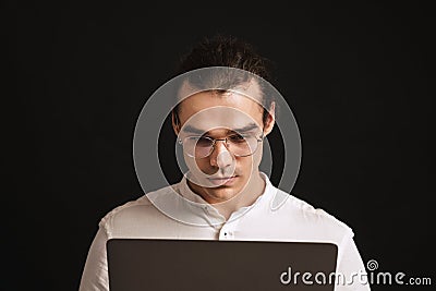 Adult long-haired man in glasses and shirt holding laptop Stock Photo