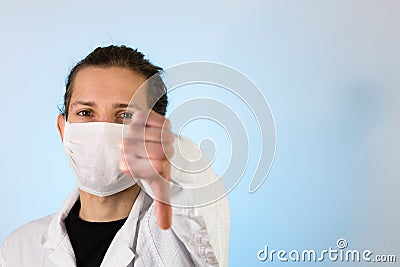An adult male dressed in a white lab coat with a protective face mask on while giving a thumbs up. Ready to work in a clean room Stock Photo