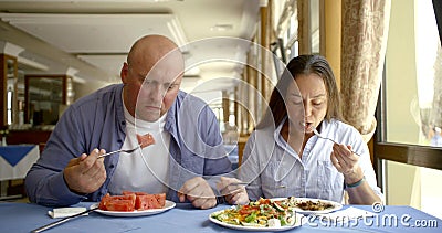 Adult male and female are having breakfast in canteen of hotel in sunny morning Stock Photo