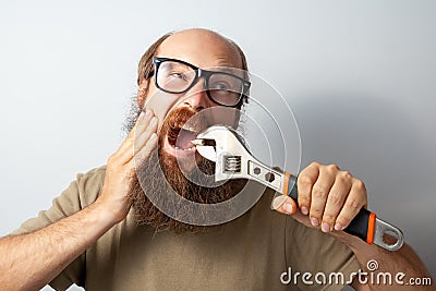 Adult male pulling out bad tooth by his own, touching cheek with hand, screaming from terrible pain. Stock Photo