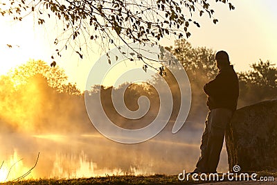 Adult Male Stands Alone At Sunrise Staring Towards Stock Photo