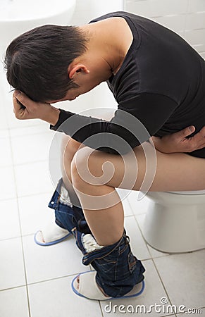 Adult man with diarrhea painful sitting toilet seat Stock Photo