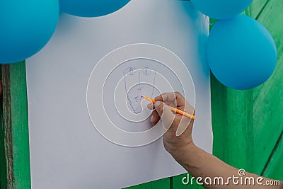 Adult man draws a face on paper. Stock Photo