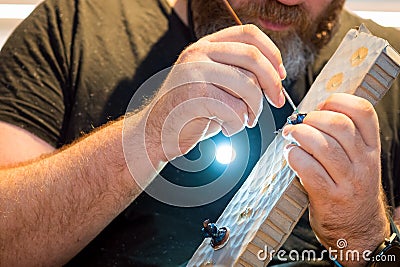Adult man painting small figures from board game Stock Photo