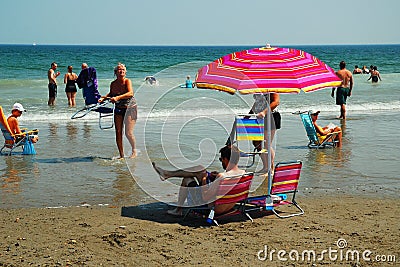 An adult man seem oblivious to the approaching tide Editorial Stock Photo