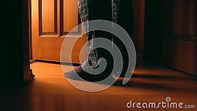 Adult man stands near door to a bathroom at the night Stock Photo