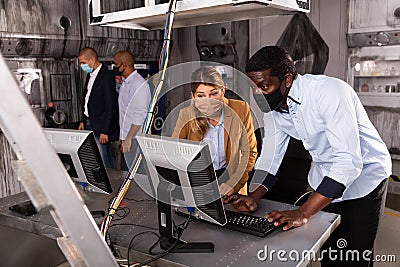 Adult man and woman in protective masks in panic looking for a solution on the computer in quest room Stock Photo