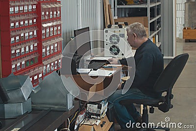 Adult man working at the computer at factory of production CNC machine with lathes Stock Photo