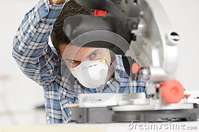 Adult master sawing platband with circular saw indoors Stock Photo
