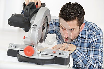 adult master sawing platband with circular saw indoors Stock Photo