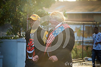 Adult men in original masquerade costumes walk by city street at dominican carnival Editorial Stock Photo