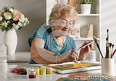Adult senior woman paints a picture in her studio Stock Photo