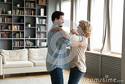 Adult son and senior mum dancing waltz in living room Stock Photo