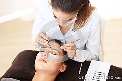 Adult woman having eyelash extension in professional beauty salon Stock Photo