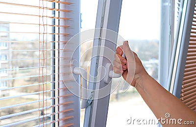 Adult woman`s hand opening a window for ventilation. Stock Photo