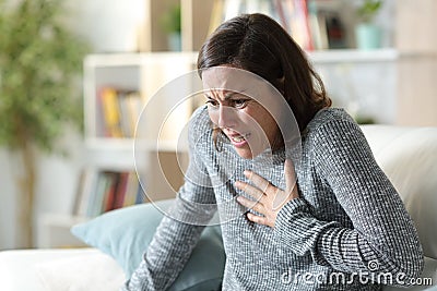 Adult woman suffering heart attack at home Stock Photo