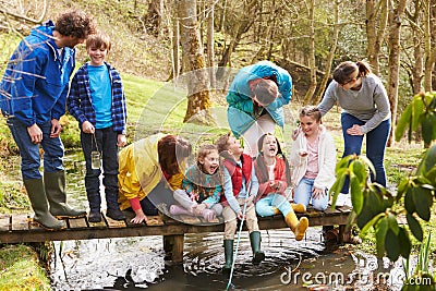 Adults With Children On Bridge At Outdoor Activity Centre Stock Photo