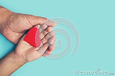 Adults and children hands holding a red heart, healthcare, love and family insurance concept, world heart day, world health day, f Stock Photo